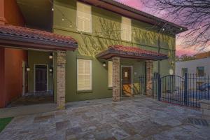 a green house with a porch and a gate at Experience Austin + 3 BR + 5 mins to Downtown! in Austin