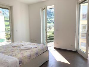ein weißes Schlafzimmer mit einem Bett und großen Fenstern in der Unterkunft Studio für 6 Personen ca 80 qm in Levanto, Italienische Riviera Italienische Westküste - b60741 in Levanto