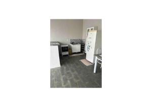 una stanza vuota con cucina e frigorifero di kitnet/Loft/Edícula ampla Aracatuba/Birigui ad Araçatuba