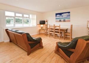 a living room with chairs and a table and a dining room at Anglesey Bungalows in Trearddur