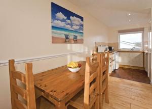 una cocina con una mesa de madera y algunos plátanos en ella en Anglesey Bungalows en Trearddur