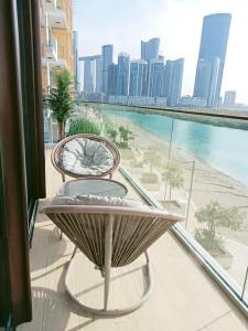a table and chairs on a balcony with a view of the city at Enjoy Luxury Condo with Sea View in Abu Dhabi