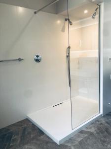 a glass shower stall in a white room at Orpheus Lodge in Giverny