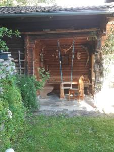 une chaise assise à l'extérieur d'une cabane en rondins dans l'établissement Haus Bernkogelblick, à Goldegg