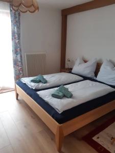 - une chambre avec 2 lits et des serviettes dans l'établissement Haus Bernkogelblick, à Goldegg