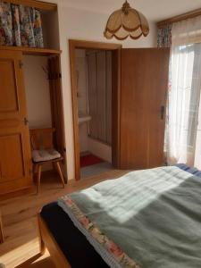 a bedroom with a bed and a chandelier at Ferienhaus Haus Bernkogelblick in Goldegg in Goldegg +13 photos