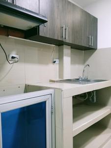 una cocina con fregadero y armarios de madera en Hostal Martha, en Neiva
