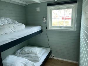 a room with two bunk beds and a window at Brustranda Fjordcamping in Valberg