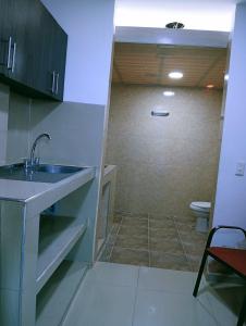 a small bathroom with a sink and a toilet at Hostal Martha in Neiva