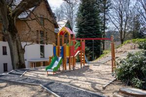 um parque infantil em frente a uma casa em Apartament B28 Green Resort dwupoziomowy z Basenem, Sauną, Jacuzzi - 5D Apartments em Szklarska Poręba