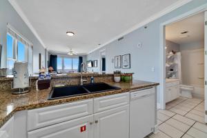 a kitchen with white cabinets and a sink at Island Royale 701 in Gulf Shores