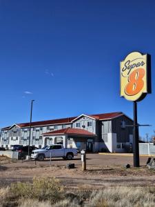 a sign for a super motel in a parking lot at Super 8 by Wyndham Holbrook in Holbrook