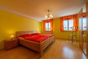 a bedroom with a bed with red sheets and yellow walls at Ferienhaus in Bärnau mit Großem Garten in Bärnau