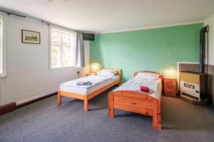 2 Betten in einem Zimmer mit grünen Wänden in der Unterkunft Alandblick in Wanzer