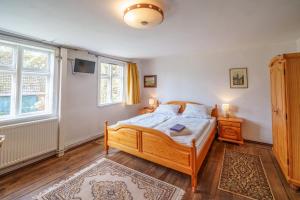 um quarto com uma cama de madeira e 2 janelas em Alandblick em Wanzer