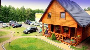 a large wooden house with cars parked in a parking lot at Ferienhaus in Bobolin mit Terrasse, Garten und Grill in Bobolin