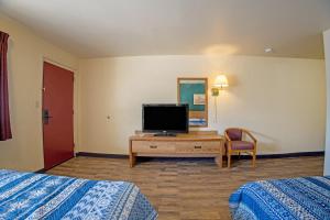 a hotel room with two beds and a flat screen tv at Holiday Motel, Lordsburg By OYO in Lordsburg