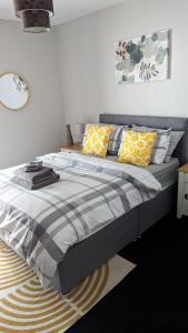 a bedroom with a bed with yellow and gray pillows at Eakie House Apartments - Kinlochleven in Kinlochleven
