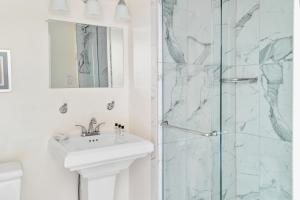 een witte badkamer met een wastafel en een douche bij Beekman Arms and Delamater Inn in Rhinebeck