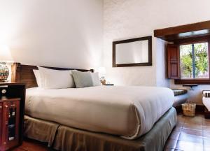 a bedroom with a large bed and a window at Quinta Real Oaxaca in Oaxaca City