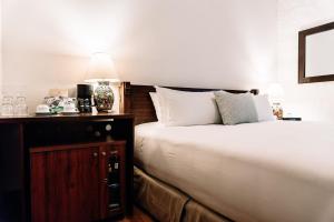ein Schlafzimmer mit einem Bett und einem Nachttisch mit einer Lampe in der Unterkunft Quinta Real Oaxaca in Oaxaca de Juárez