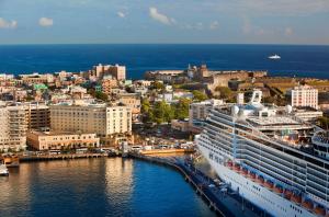 um navio de cruzeiro ancorado num porto ao lado de uma cidade em Hotel Rumbao, a Tribute Portfolio Hotel em San Juan