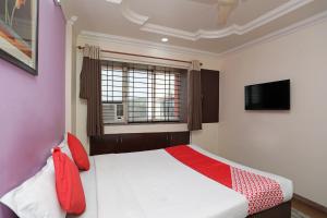 a bedroom with a bed with red pillows and a window at OYO Hotel Bliss Executive Near Sant Tukaram Nagar Metro Station in Chinchwad