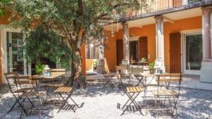 um grupo de cadeiras e mesas em frente a um edifício em Schönes Appartement in Toscolano Maderno mit Terrasse und Garten em Toscolano Maderno