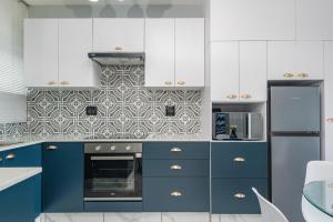 una cucina con armadi blu ed elettrodomestici bianchi di Trendy @ La Ballito 503 a Ballito
