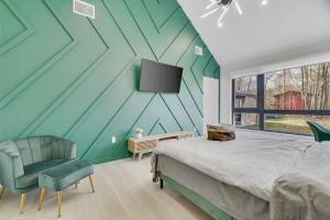 1 dormitorio con una pared verde, 1 cama y TV en The Barn House by AvantStay Modern Outdoor Living Area Hot Tub, en Albrightsville
