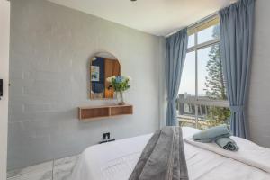 Un dormitorio con una cama con espejo y una ventana. en Trendy @ La Ballito 503, en Ballito 38 fotos más