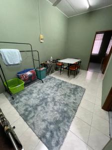 una habitación con una alfombra y una mesa con una mesa en Salam homestay en Kepala Batas