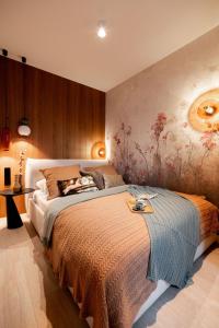 a bedroom with a bed and a painting on the wall at Scala Apartments by Blue Mandarin in Gdańsk