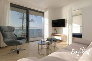 ein Wohnzimmer mit einer Couch und einem Sessel in der Unterkunft Double Blue Bien - Easy-Rent Apartments bezpośrednio przy plaży in Rewal