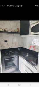 a kitchen with a stove and a microwave at Apto Sirius 31 in Cascavel