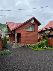ein Holzhaus mit rotem Dach in der Unterkunft Holidaj Home in Synewyrska Poljana