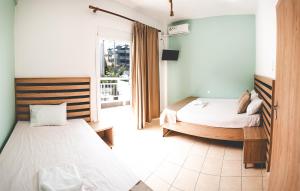sypialnia z dwoma łóżkami i oknem w obiekcie Μpasias Apartments w Paralii Katerinis