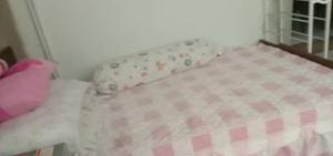 a small bed with a pink and white bedspread at Sobey Laris Homestay PASIR MAS LATI in Pasir Mas