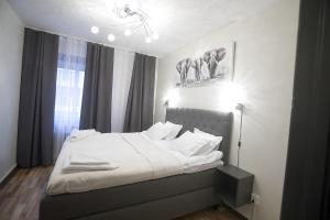 a bedroom with a bed with white sheets and pillows at Hotell Kungsbacken in Katrineholm