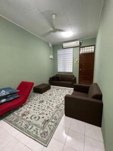a living room with a couch and a rug at Salam homestay in Kepala Batas