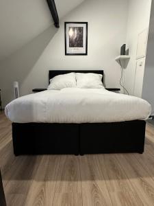 um quarto com uma cama grande e lençóis brancos em Modernes Loft am Dreiländereck em Alsdorf