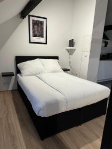 um quarto com uma cama grande e lençóis brancos em Modernes Loft am Dreiländereck em Alsdorf