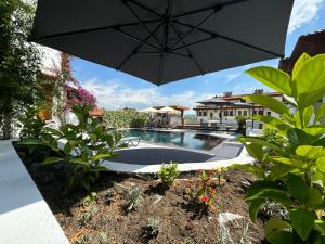 an umbrella over a swimming pool in a yard at Tomsan Villas Akyaka in Akyaka