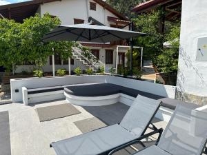 阿奇亞卡的住宿－Tomsan Villas Akyaka，庭院配有两把椅子和一把遮阳伞