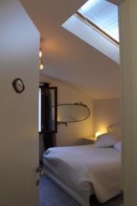 1 dormitorio con cama blanca y ventana en I Campi di Lino, en Finale Ligure