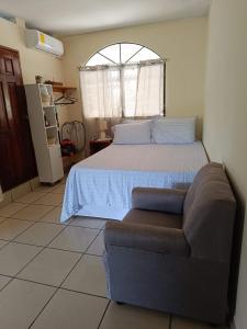 - une chambre avec un lit, un canapé et une fenêtre dans l'établissement 23 Villa del Mar, à La Libertad