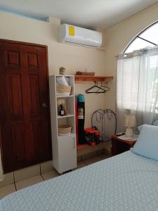 - une chambre avec un lit, un placard et une porte dans l'établissement 23 Villa del Mar, à La Libertad
