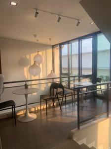 HAKKA Wellness Residence في ساموت سونكرام: غرفة طعام مع طاولات وكراسي ونوافذ