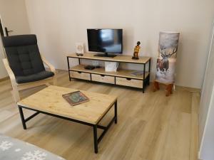 a living room with a tv and a coffee table at Gite du Vieux Tonneau in Cerdon