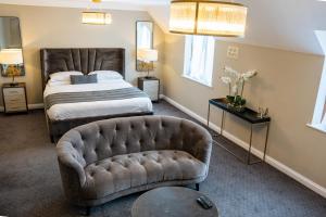 um quarto com uma cama e um sofá em The Pear Tree Inn & Country Hotel em Worcester